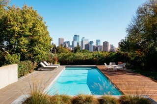 Although previous owners built a pool at a lower part of the yard near the piano room, the couple decided to build a new one just off the kitchen. “We thought, it would be amazing to have a pool that was kind of jutting out, with the backdrop of the city,” John says. The patio doubles as entertaining space for summer parties.