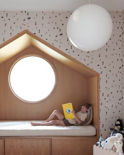 In a spare bedroom/playroom located in another section of the house, Berg played with juxtapositions of shapes, installing an oak-wrapped, triangular reading nook inset with a circular window.