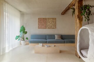 In the new living room, the floors are covered in pine wood with a Bona Craft Oil finish in Frost, and the walls and ceiling are coated in lime plaster, Mortex by Beal. The handmade hanging chair, made of plaster, is a favorite spot for the couple’s cat, Paka.