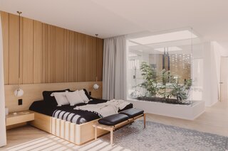 The master bedroom living area is separated from the bedroom by a glass-enclosed, plant-filled courtyard that also provides ventilation to the bathroom and wardrobe.