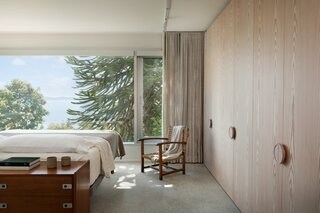 The team carried through the same Douglas Fir millwork featured in the kitchen into the primary bedroom. These intentional material choices connect the interior to the locale, as Douglas Fir is a native tree species to the coast of British Columbia.