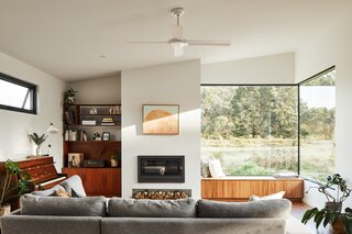 Though the living room only has large windows on one side, an upper window at left helps create what the clients call double sunrises and sunsets, by creating reflections on the larger windows at right.