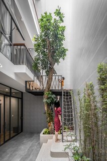 Vietnam-based firm Story Architecture designed this 1,259-square-foot home for a young family in Ho Chi Minh City’s District 7. In the light-filled atrium, a tree with a built-in climbing structure provides a unique indoor playground for the children.