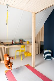 A Rafa Kids swing hangs below the loft bed near the large desk designed for playing with Legos. 