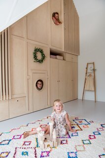 Behind the door of the floor-to-ceiling cabinet in Cato's room is a small play area as well as a staircase that leads to an upper-level play space. 