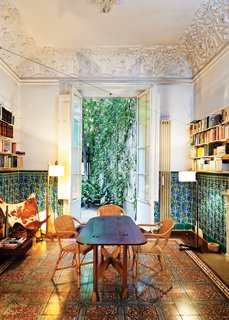 In the dining room, which opens to the backyard terrace, original tilework on the floors and walls complement decidedly modern counterparts—an original 1938 Butterfly chair 

by Antonio Bonet, Juan Kurchan, and Jorge Ferrari Hardoy, and a 1983 TMC floor lamp by Spanish designer Miguel Milá.