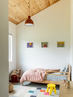 In the second bedroom, an IKEA bed and West Elm rug bring a sense of playfulness, complemented by a pendant light from Muuto.
