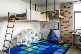 The clients' teenage son was given a more colorful bedroom with an elevated bed and a small climbing wall. 
