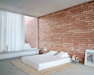The couple’s bedroom opens directly into a private recessed courtyard, offering an intimate space to gather away from the busy street above.