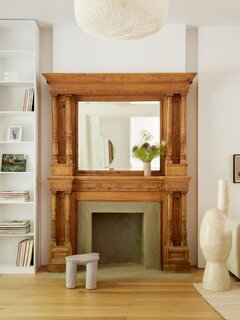 The fireplaces juxtapose ornamental wood and a modern concrete finish on the firebox surround.
