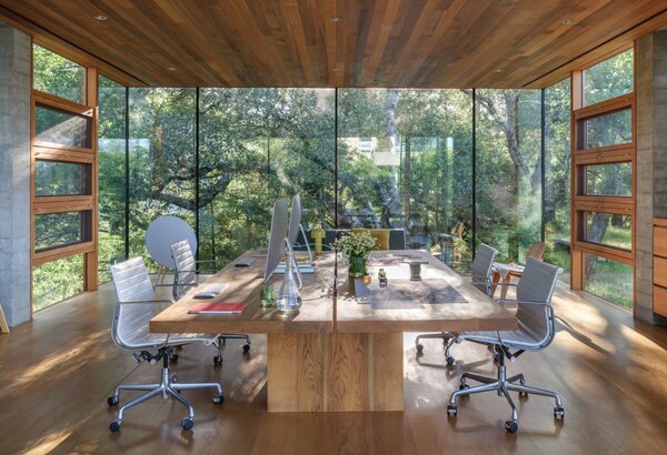 The glass walls frame large expanses of greenery.