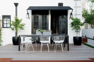 The home's wood deck is a neutral base that compliments the home's back and white features.