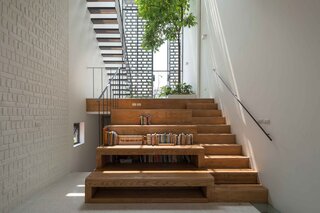 The stepped wooden platforms provide built-in seats for the library. Down the stairs to the left is a guest room.